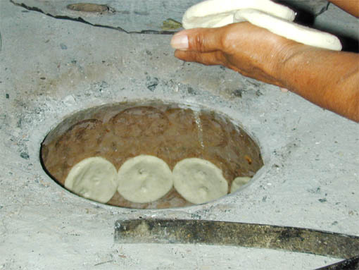  Antes de poner las memelas se extraen el  carbón que ya habrán caldeado la superficie.